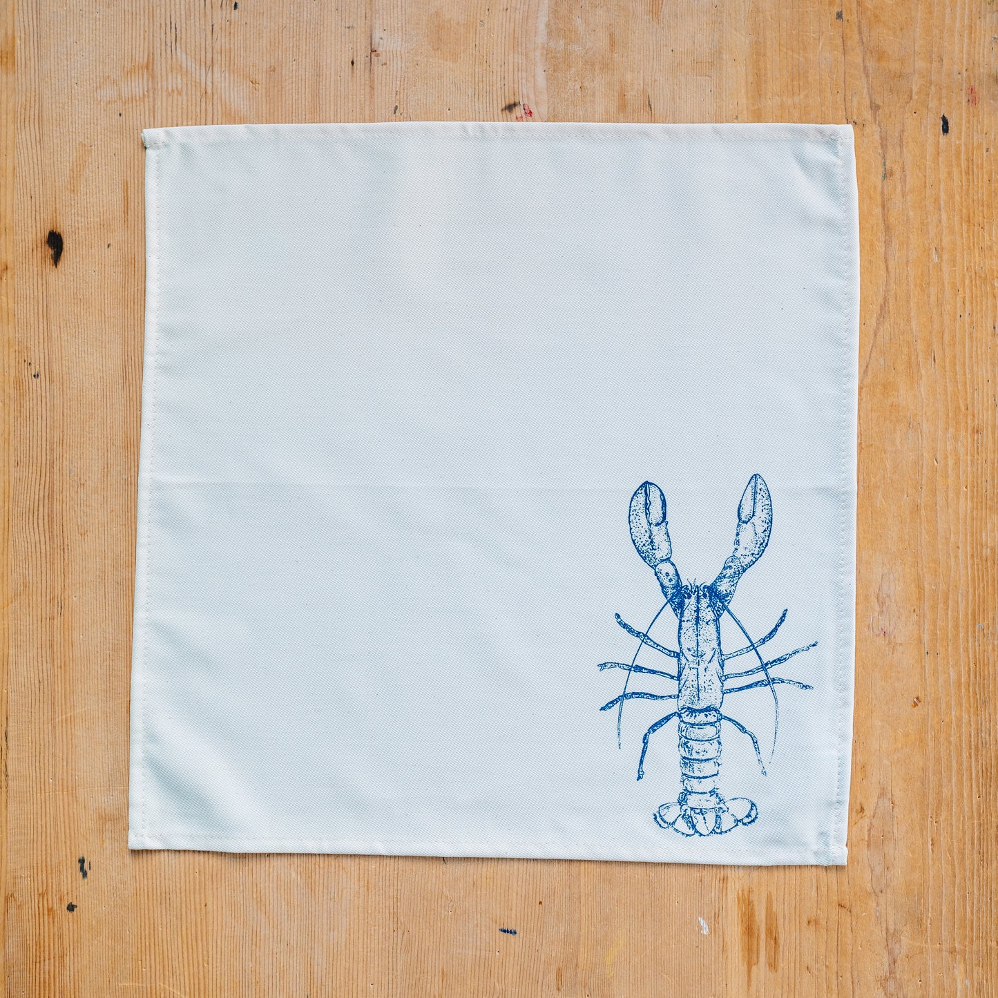 Seafood napkin gift set by Lottie Day featuring handprinted crab, blue lobster, prawn, mackerel, samphire and lemon illustrations on cotton napkins